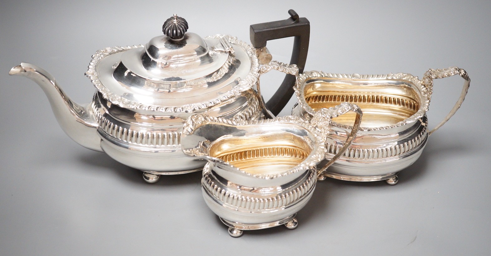 A George V silver three piece tea set, with fluted band, Nathan & Hayes, Chester, 1913/4